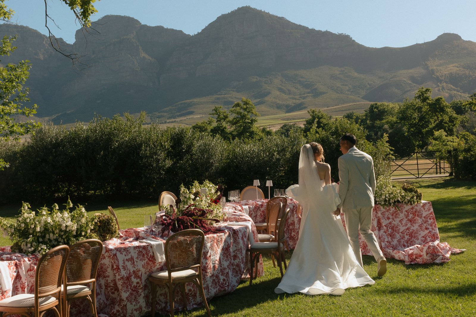 Couple beside long table reception with Simonsberg mountain views