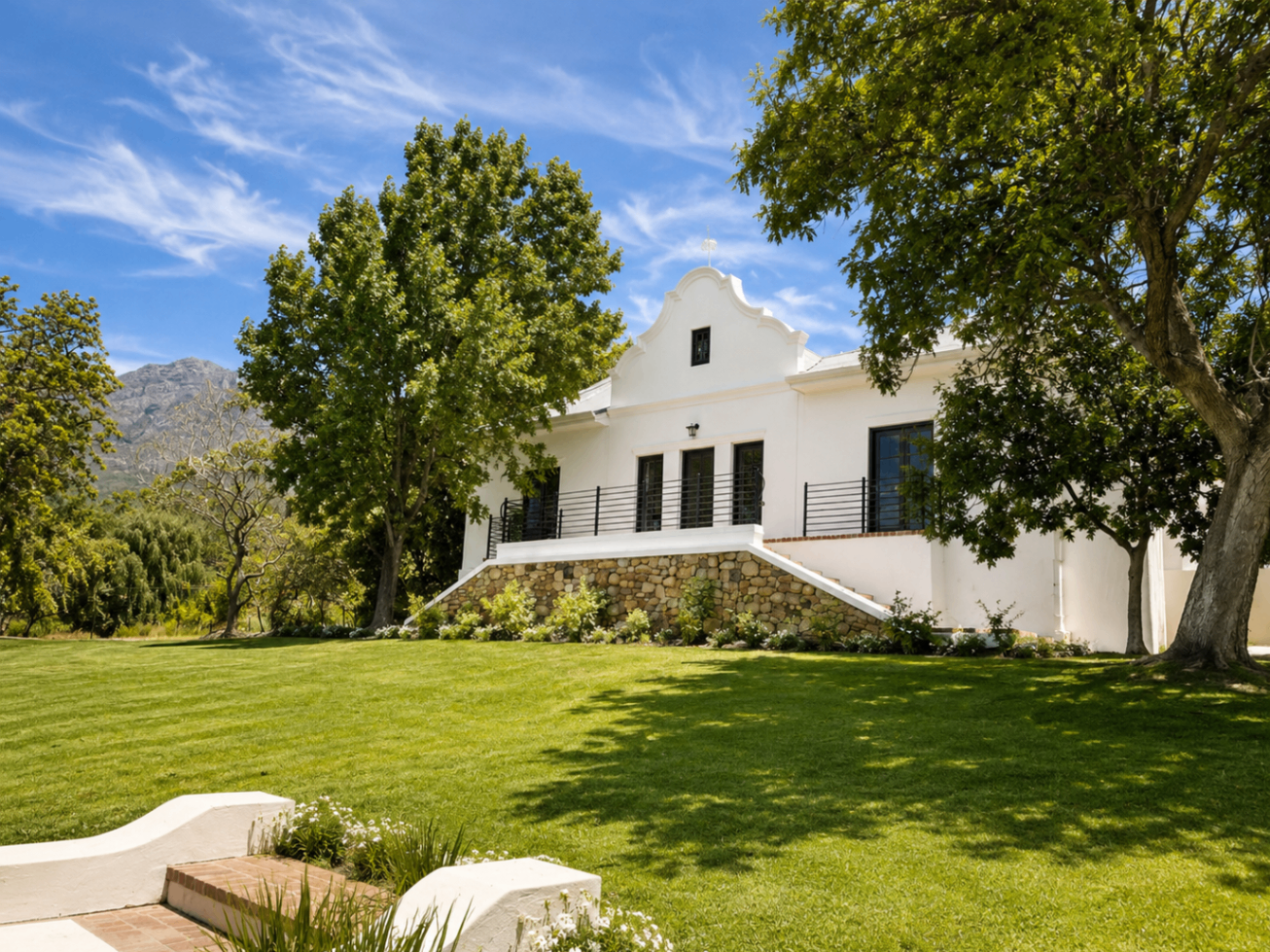 Wild Olive Manor House exterior with mountain backdrop and lawn