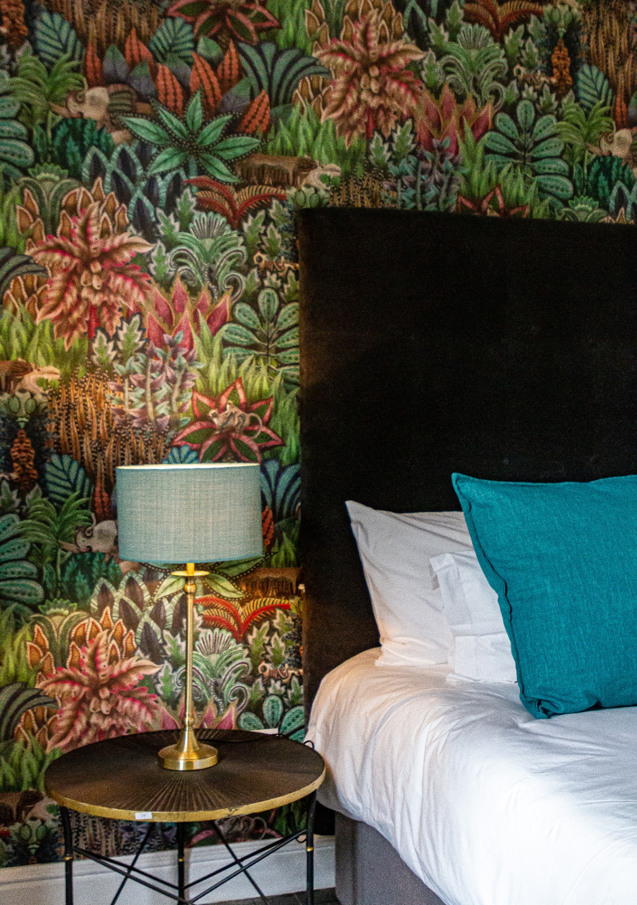 Merle Cottage bedroom with botanical wallpaper and velvet headboard