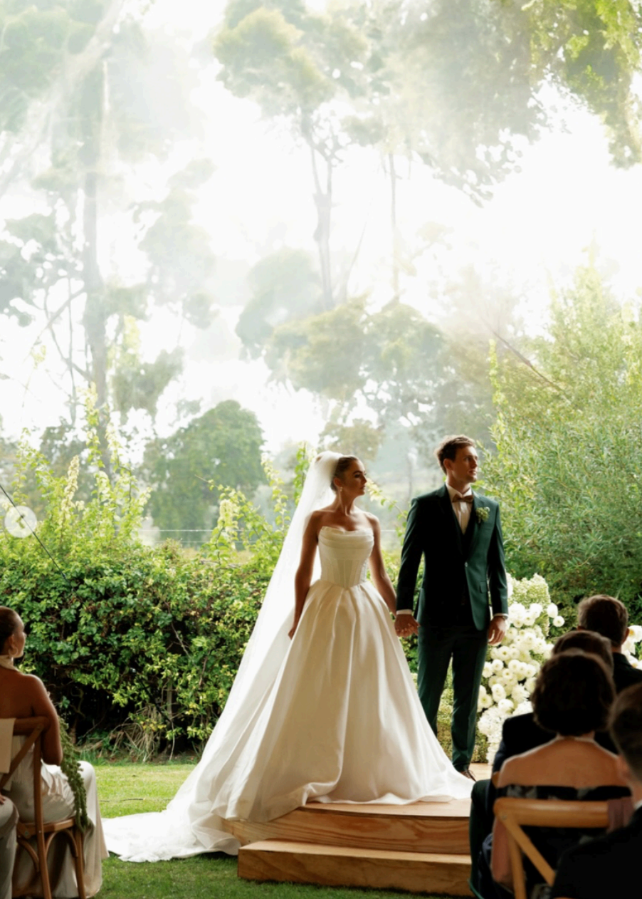 Bride and groom standing together during an outdoor ceremony