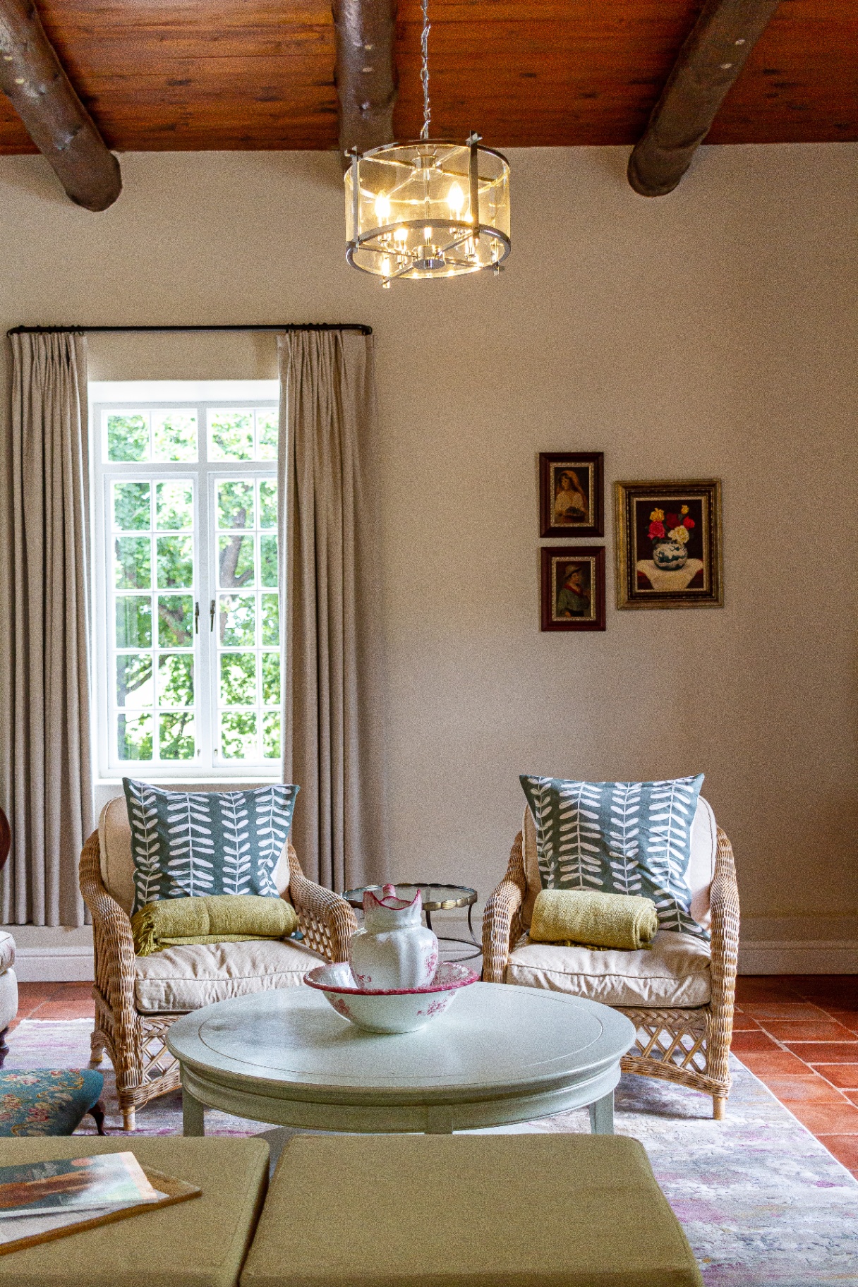 Lady Grey Suite lounge with wicker chairs, beamed ceiling and chandelier