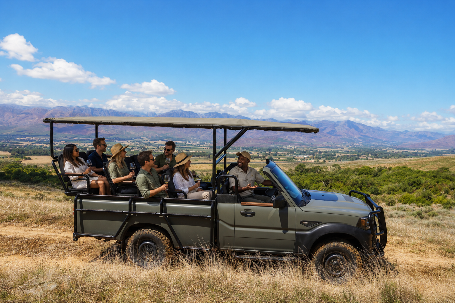Guests enjoying the Plaisir Vineyard Safari vehicle with panoramic mountain views