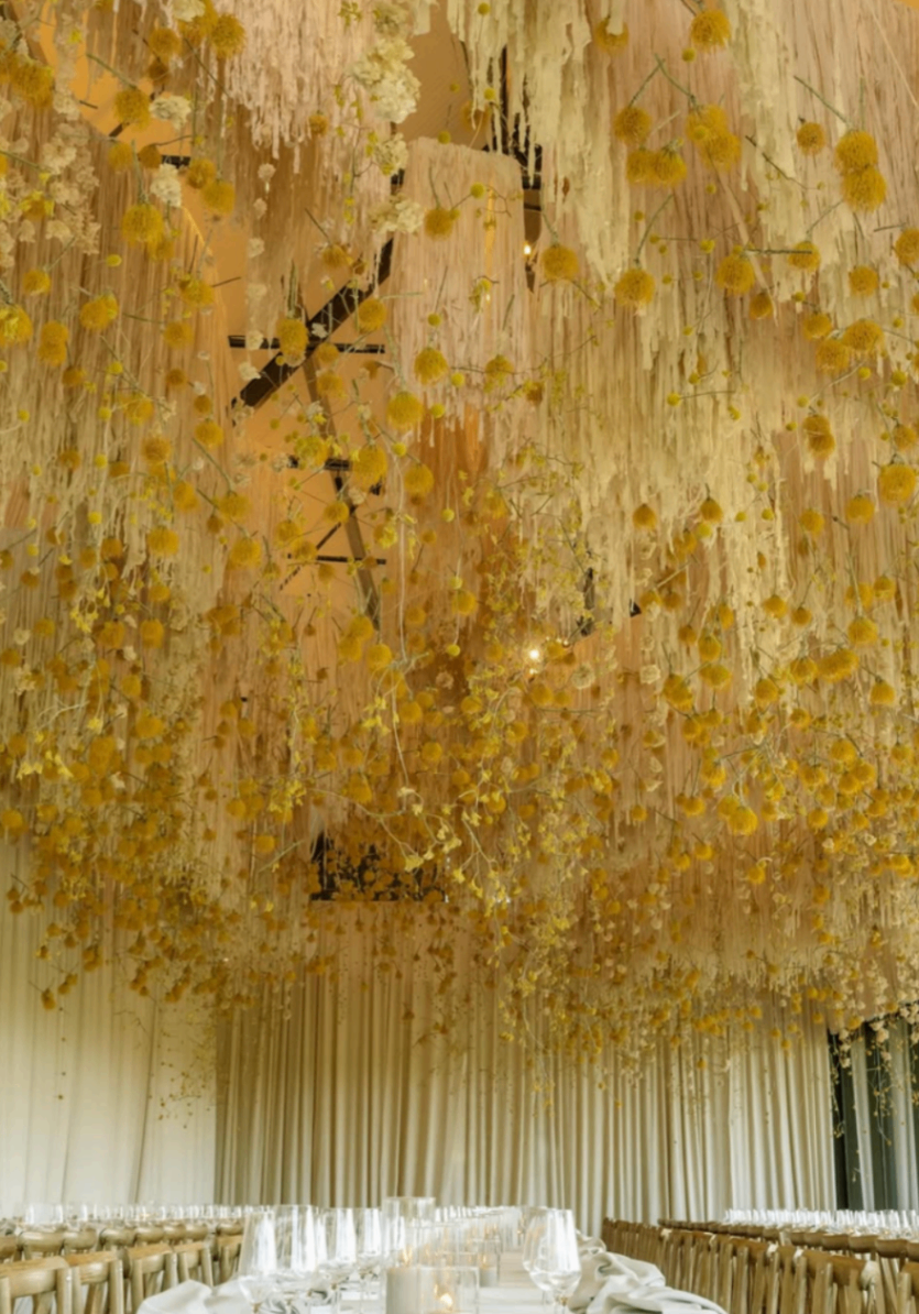 Floral installation suspended above a long reception table