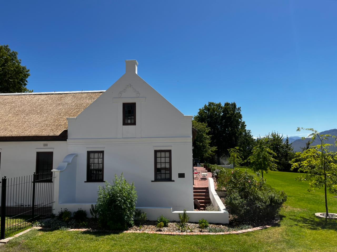 Old Mill Suite exterior with thatched roof and Cape Dutch gable