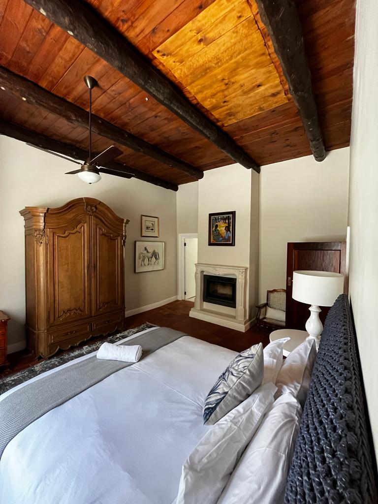 Manor Suite bedroom with wood-beam ceiling and fireplace