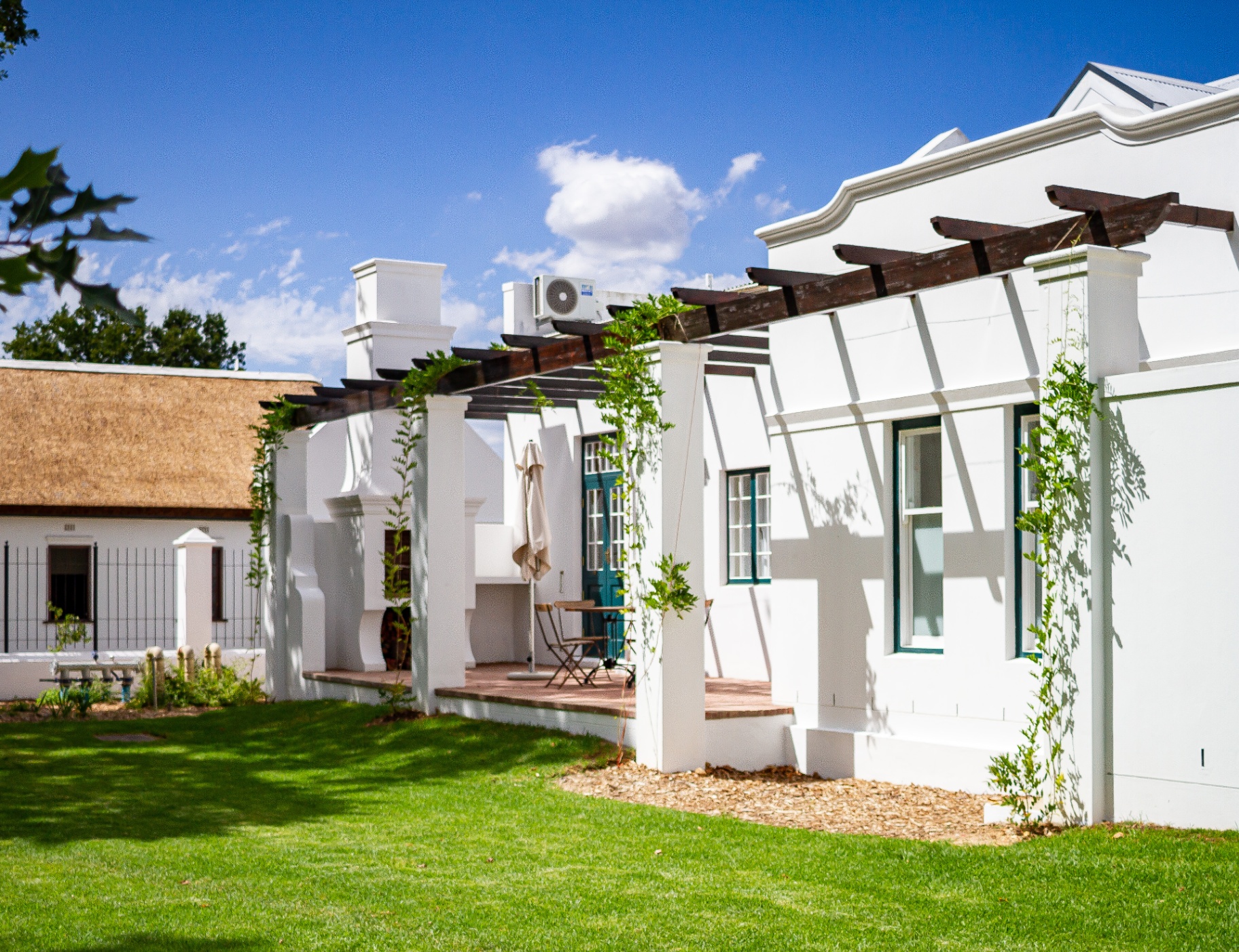 Old Mill Suite back veranda and braai area with pergola and garden